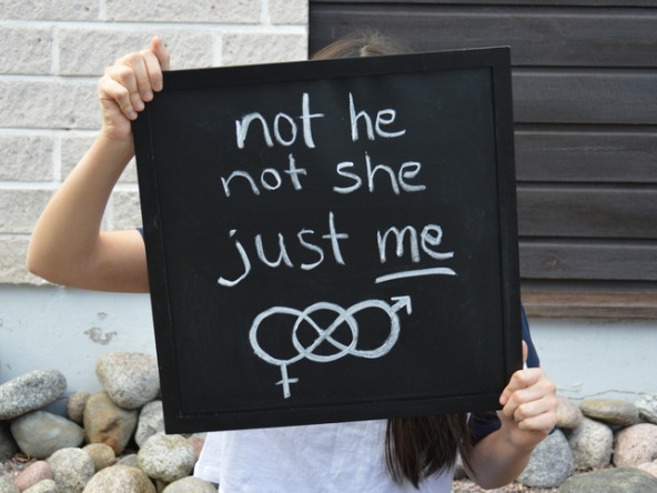 Blackboard with chalk writing held up by teenager